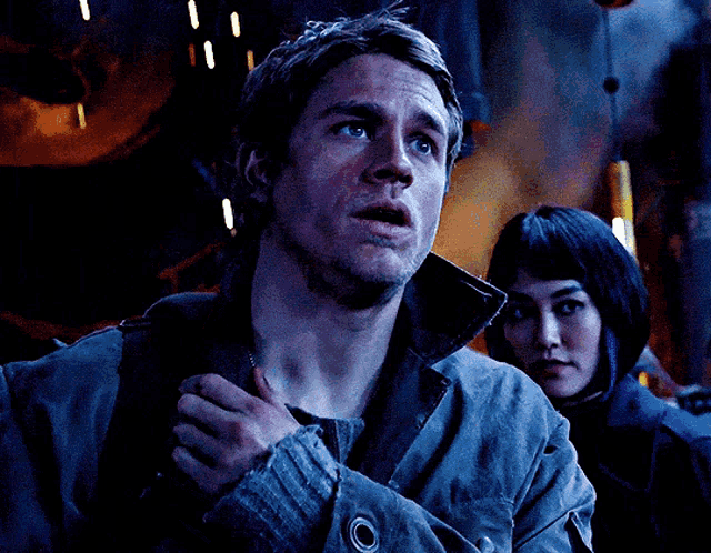 a man with his hand on his chest is looking at the camera