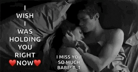 a black and white photo of a man and a woman hugging in bed .