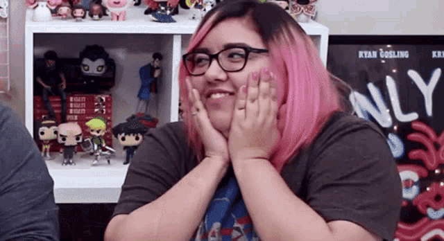 a woman with pink hair and glasses is smiling in front of a poster that says only
