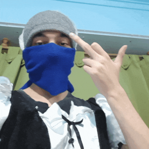a person wearing a maid outfit and a blue mask giving the middle finger