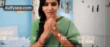 a woman in a green shirt is being recorded on a video camera