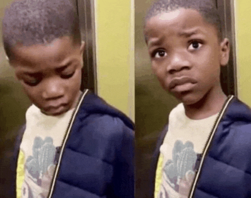 a young boy in an elevator is making a funny face .