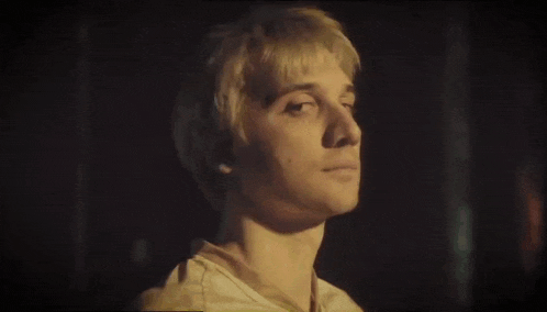 a close up of a young man 's face with blonde hair