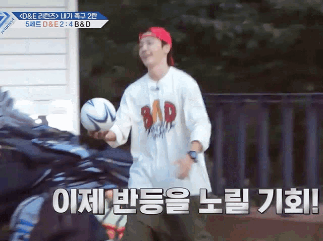 a man wearing a shirt that says bad holds a soccer ball