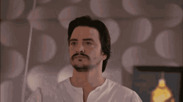a man with a beard in a white shirt