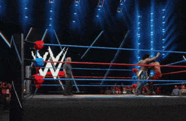 a man is laying on the ground in a wrestling ring with a w logo in the background