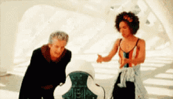 a man and a woman are standing next to each other in a white room .