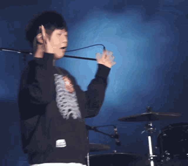 a man wearing a black sweatshirt with a skeleton on the front
