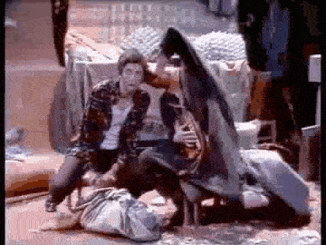 a man in a plaid shirt is kneeling down next to a woman in a high heeled shoe .