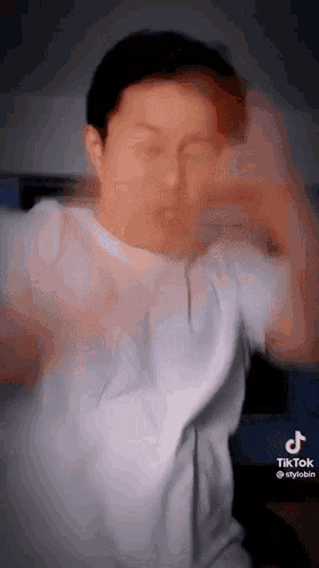a man in a white t-shirt is making a funny face