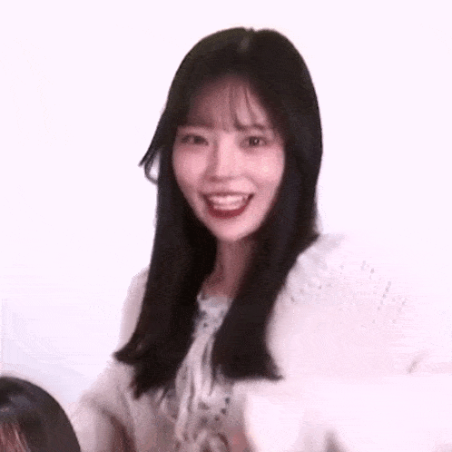a young woman with long black hair and bangs is smiling .