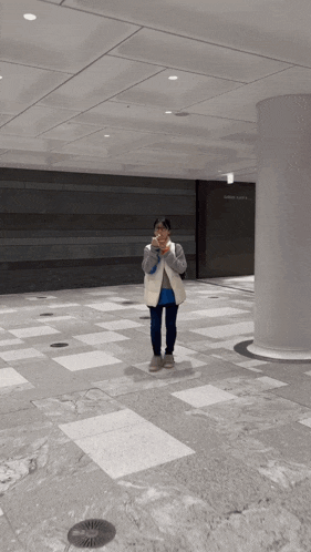 a person standing on a tiled floor in front of a sign that says ' garden plaza ' on it