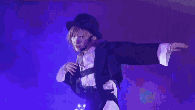 a woman wearing a black hat and a purple shirt holds a piece of paper in her hand