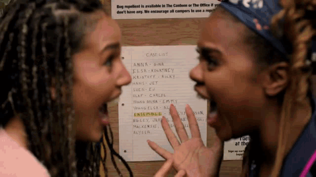 two women are standing in front of a case list on a wall