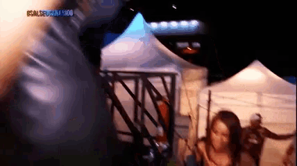 a group of people are standing in front of a tent with a sign that says ' samsung ' on it .