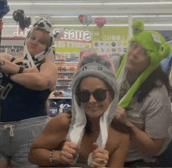 a group of women are posing for a picture in front of a sign that says sale