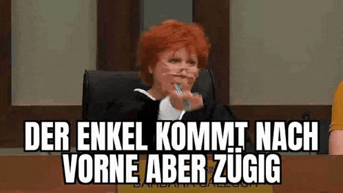a judge with red hair is sitting in a courtroom holding a pen in her mouth and making a funny face .