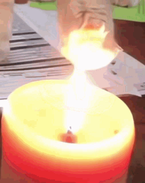 a close up of a candle with flames coming out of it on a table