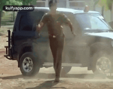 a man is running away from a police car in a dirt road .