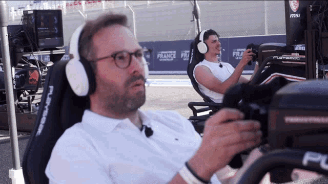 a man wearing headphones sits in a chair with the word france on the back