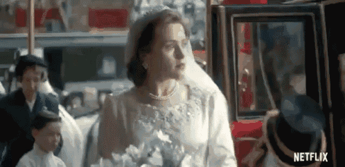 a woman in a wedding dress is standing next to a carriage .
