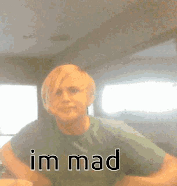 a man in a green shirt with the words im mad written on the bottom