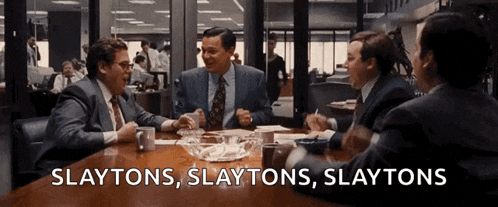 a group of men are sitting at a table with the words slaytons slaytons slaytons