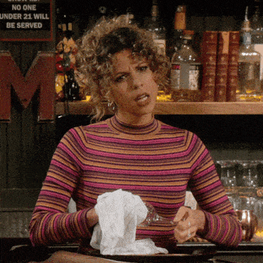 a woman wipes her mouth with a napkin in front of a sign that says " no one under 21 will be served "