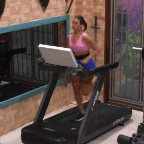 a woman in a pink top is running on a treadmill that says xtreme