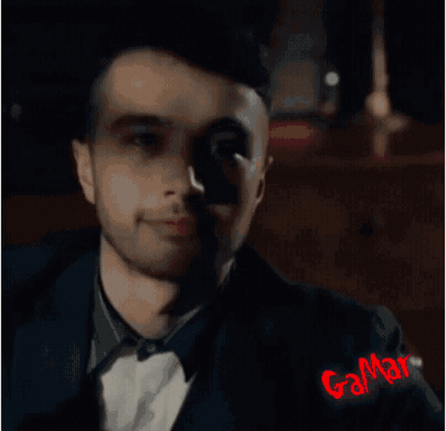 a man in a tuxedo with the word gamar written on the bottom