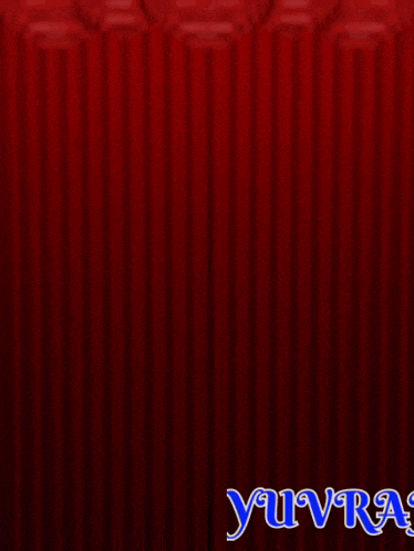 a man wearing sunglasses is behind a red curtain with the name yuvr on it