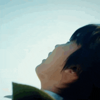a woman is looking up at the sky with her eyes closed .