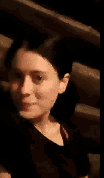 a woman in a black shirt looks at the camera