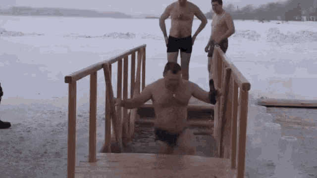 a man in a bathing suit is walking out of a frozen lake .