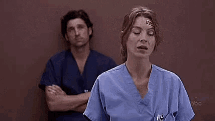 a woman in scrubs is standing in front of a man with his arms crossed and says `` du fehlst mir '' .