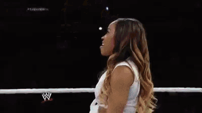 a woman in a white shirt is dancing in a ring .
