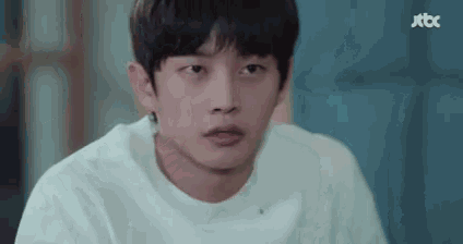 a close up of a young man wearing a white t-shirt .