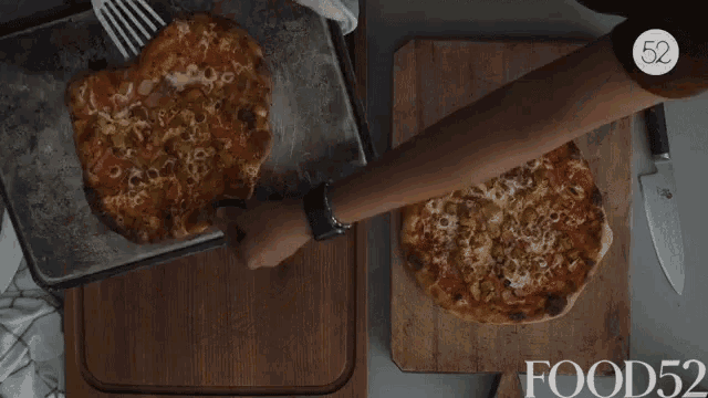 a person is cutting a pizza on a wooden cutting board with the words food52 on the bottom