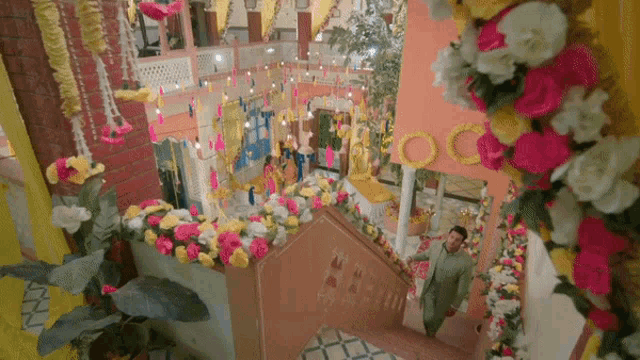 a man is walking down a set of stairs decorated with flowers