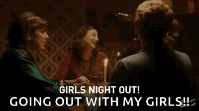 a man and two women are talking to each other in a room .