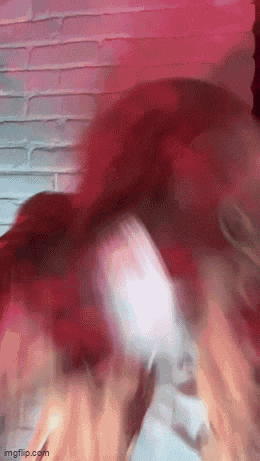 a blurry picture of a person dancing in front of a red wall .