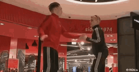 two men are dancing in a store with a sign that says 1974 on it