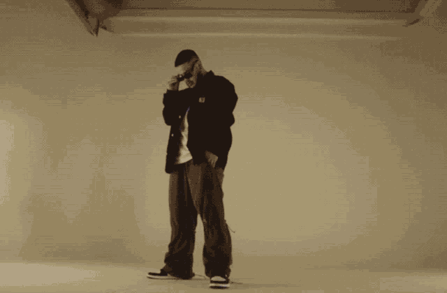 a man in a carhartt jacket stands in front of a white wall