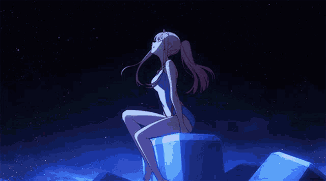 a girl in a swimsuit is sitting on a cube looking up at the stars