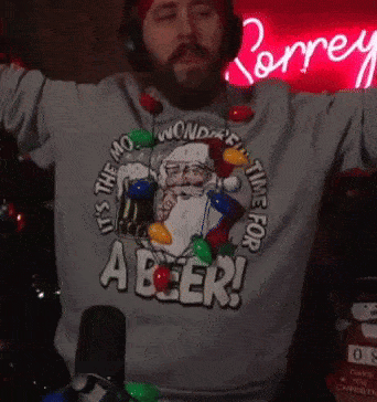 a man wearing headphones and a sweater that says it 's the mo wonderful time for a beer .