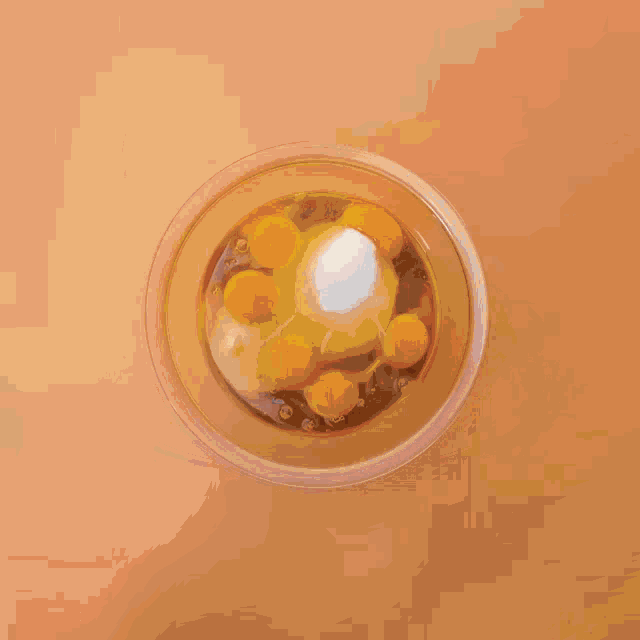 a person is pouring chocolate into a bowl of orange juice
