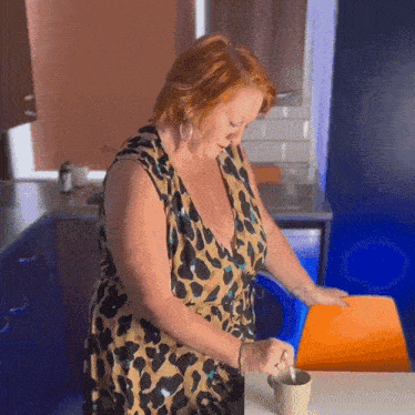 a woman in a leopard print dress holds a cup of coffee