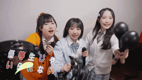 three girls are standing next to each other holding microphones and a tambourine