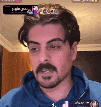 a man with a beard is wearing a blue shirt that says ' aysr ' on it