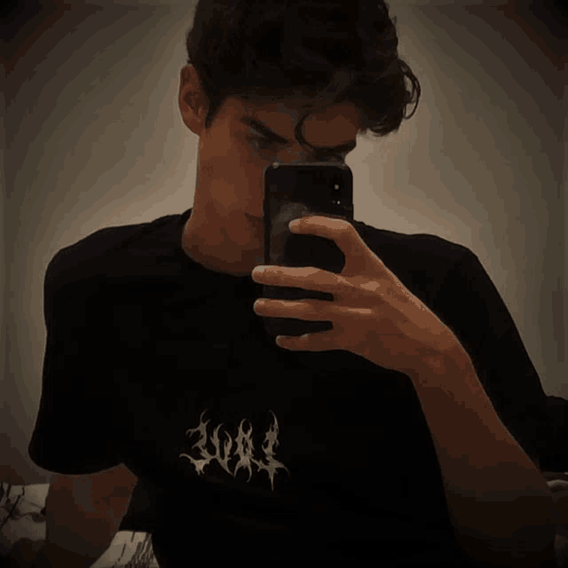 a young man is taking a selfie with his phone and his shirt says 2001